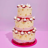 3 Tier Raspberry & White Chocolate Cake with buttercream, raspberry meringues, white chocolate truffles, and gold leaf accents.
